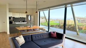 a living room with a blue couch and a table at Jog Lodge 2 By Together Travel - 3 Bed in John O Groats