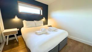 a bedroom with a bed with two towels on it at Jog Lodge 2 By Together Travel - 3 Bed in John O Groats