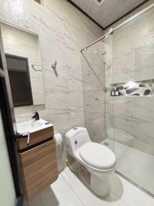 a bathroom with a toilet and a shower and a sink at Aparta Hotel La Osadía in Acacías +16 photos