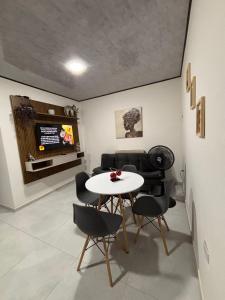 a room with a table and chairs and a television at Aparta Hotel La Osadía in Acacías