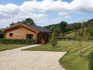 a small wooden cabin with a garden and a tree at 3 Bed in Bridgwater oc-56284 in Greinton