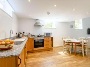 a kitchen with wooden cabinets and a table with a bowl of oranges at 2 Bed in Fordingbridge oc-56823 in Woodgreen +12 photos