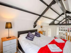 a bedroom with a bed with white sheets and purple pillows at 2 Bed in Fordingbridge oc-56823 in Woodgreen