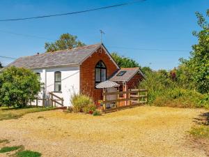 a small white and red house with a fence at 2 Bed in Fordingbridge oc-56823 in Woodgreen