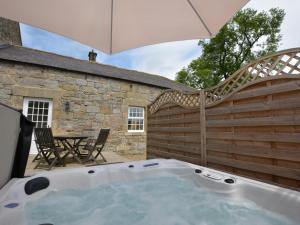 a hot tub in a backyard with an umbrella at 1 Bed in Newcastle Upon Tyne oc-49414 in Rochester +3 photos