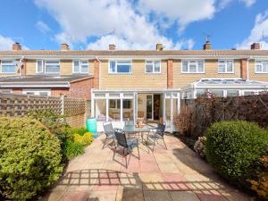 a house with a patio and a table and chairs at Orchard Mews , Barnham in Barnham