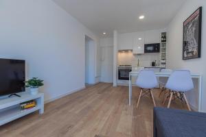 a kitchen and living room with a table and chairs at Carcavelos Village I by Staycalm in Carcavelos +5 photos