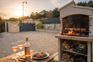 a table with glasses of wine and a fire grill at Loge au ptitbonheur in Savasse