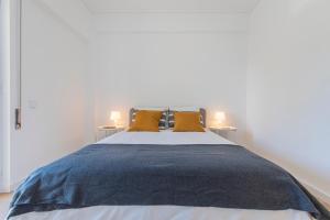 a bedroom with a large bed with yellow pillows at Carcavelos Village I by Staycalm in Carcavelos