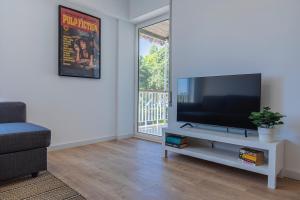 a living room with a flat screen tv on a white cabinet at Carcavelos Village I by Staycalm in Carcavelos