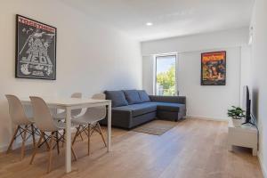 a living room with a blue couch and a table at Carcavelos Village I by Staycalm in Carcavelos