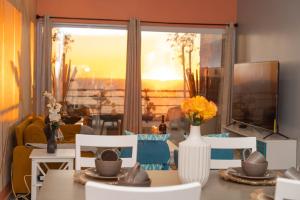 a living room with a table and chairs and a window at Rosarito Papas & ocean view Condo in Rosarito