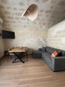 a living room with a couch and a table at Dimora Antica Santa Chiara in Trani