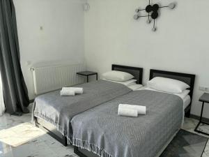 two beds in a white room with towels on them at Zveniv Resort in Oryavchyk