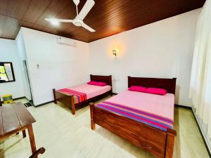 a bedroom with two beds and a ceiling at Flourish holiday resort in Kataragama +7 photos
