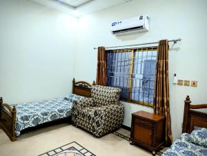 a bedroom with a bed and a chair and a air conditioner at House No 6, Valley Homes in Pothi +3 photos