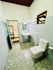 a bathroom with a toilet and a sink at Flourish holiday resort in Kataragama