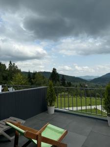 a balcony with a chair and a view of the mountains at Zveniv Resort in Oryavchyk