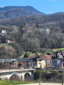 a small town with a bridge and houses on a hill at Parenthèse en Savoie in Albertville