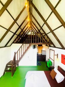 an attic room with a bed and a staircase at Rainforest Tea Garden Cabin-River View in Deniyaya