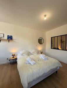 a bedroom with a large bed with towels on it at Parenthèse en Savoie in Albertville