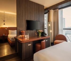 a hotel room with a bed and a tv at Hyatt Centric Milan Centrale in Milan
