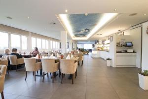 a dining room with people sitting at tables in a restaurant at Nautic Hotel Bremerhaven in Bremerhaven +48 photos