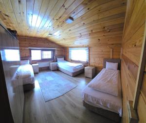 a room with two beds in a wooden cabin at Ayder Villa Bravo in Çamlıhemşin