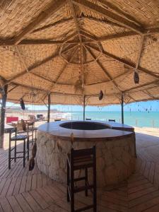 a large umbrella on a beach with chairs and a bar at maison d'hôtes la merveille in Dakhla