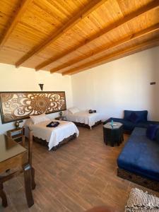 a living room with two beds and a couch at maison d'hôtes la merveille in Dakhla