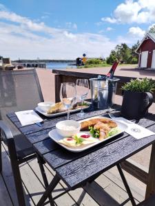 a wooden table with a plate of food and wine glasses at Spend a night on a Sailing Boat in Saltvik