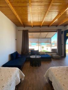 a living room with two beds and a blue couch at maison d'hôtes la merveille in Dakhla