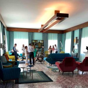 a living room with blue and red furniture and people at Villa Chamoun in Al Wādī