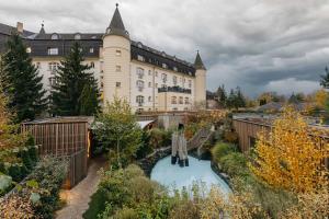 a large building with a garden in front of it at Hotel SEN in Senohraby