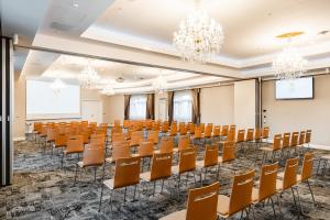 an empty conference room with chairs and a podium at Hotel SEN in Senohraby +64 photos