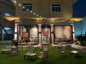 a group of chairs and tables in front of a building at Kosin House in Bangkok