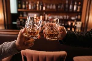 two people are holding up glasses of beer at Villa Chamoun in Al Wādī