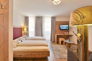 a bedroom with a bed and a tv in it at Haus Flexen rooms & apartments in Stuben am Arlberg