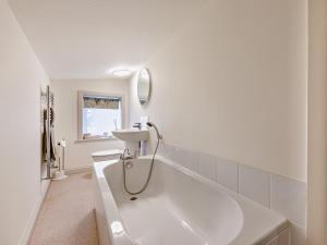 a white bathroom with a tub and a sink at 5 Bed in Halifax oc-96061 in Sowerby Bridge +35 photos