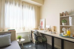 a kitchen with a desk and chairs and a window at Residencia Universitaria Resa Erasmo in Madrid +44 photos
