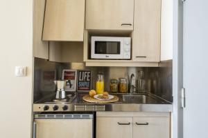 eine Küche mit einer Spüle und einer Mikrowelle in der Unterkunft Residencia Universitaria Erasmo in Madrid