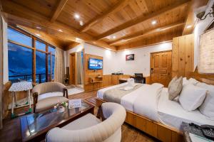 a large bedroom with a large bed and a television at Hotel SNAS Retreat Manali in Manāli