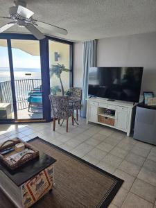 a living room with a large flat screen tv at Beachfront Condo Panama City Beach Gulf Front Views walk to Pineapple Willy's in Panama City Beach