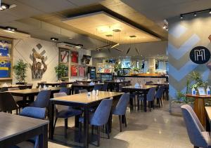 a restaurant with wooden tables and blue chairs at Maria's Hotel in La Banda