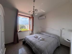 ein Schlafzimmer mit einem Bett mit Fenster und einem Waschbecken in der Unterkunft S' Agrùstu in Orosei