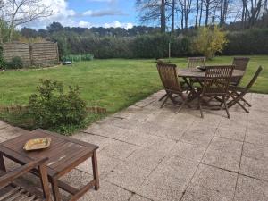 a wooden table and chairs sitting on a patio at Golf Home in Écommoy