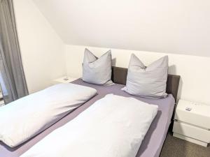 a bed with white sheets and pillows in a room at Apartment Graugans by Interhome in Freiburg - Elbe