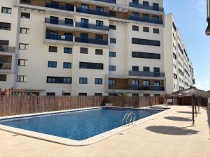 a swimming pool in front of a tall building at Rio Nacimiento in Campoamor