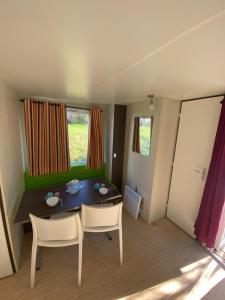 a small room with a table and two chairs at Camping Lac aux Oiseaux - Mobil-home 3 Pièces 4 Personnes MAE-0991 in Martiel