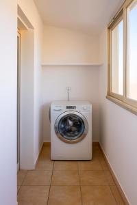 a washing machine in a laundry room with a window at Sestu house via monserrato rooms in Sestu
